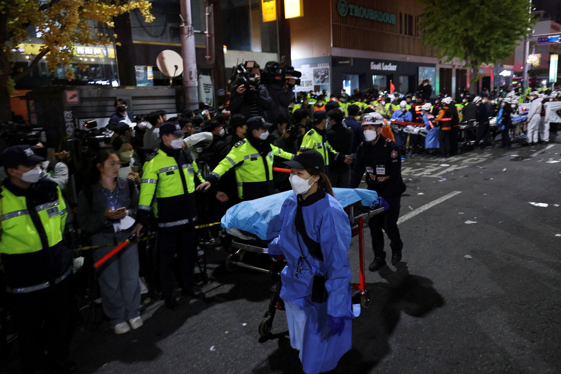 Rescue team members move a body at the scene where dozens of people were injured in a stampede during a Halloween festival in Seoul, South Korea, October 29, 2022. REUTERS/Kim Hong-ji