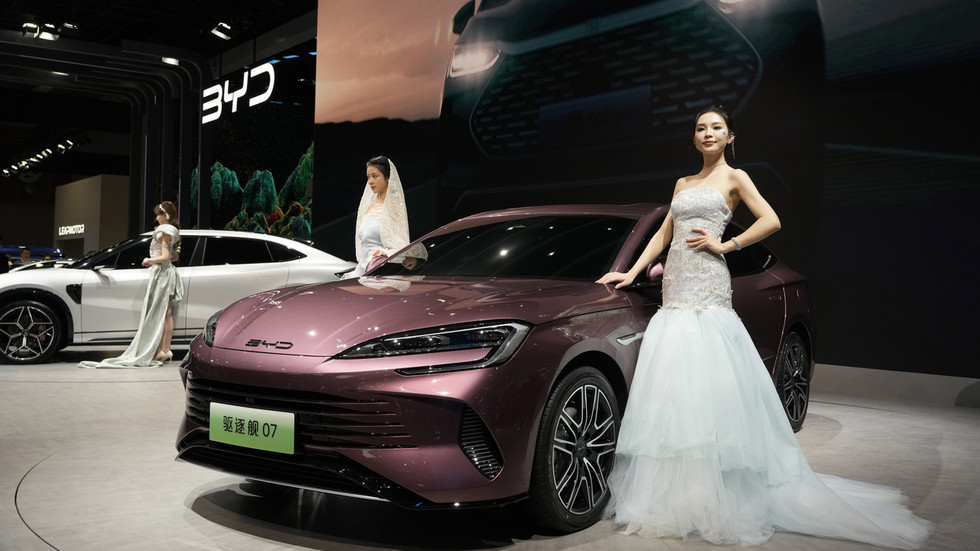 Models pose near the latest offering from Chinese automaker BYD during the Auto Shanghai 2023 show in Shanghai, April 19, 2023 © AP / Ng Han Guan